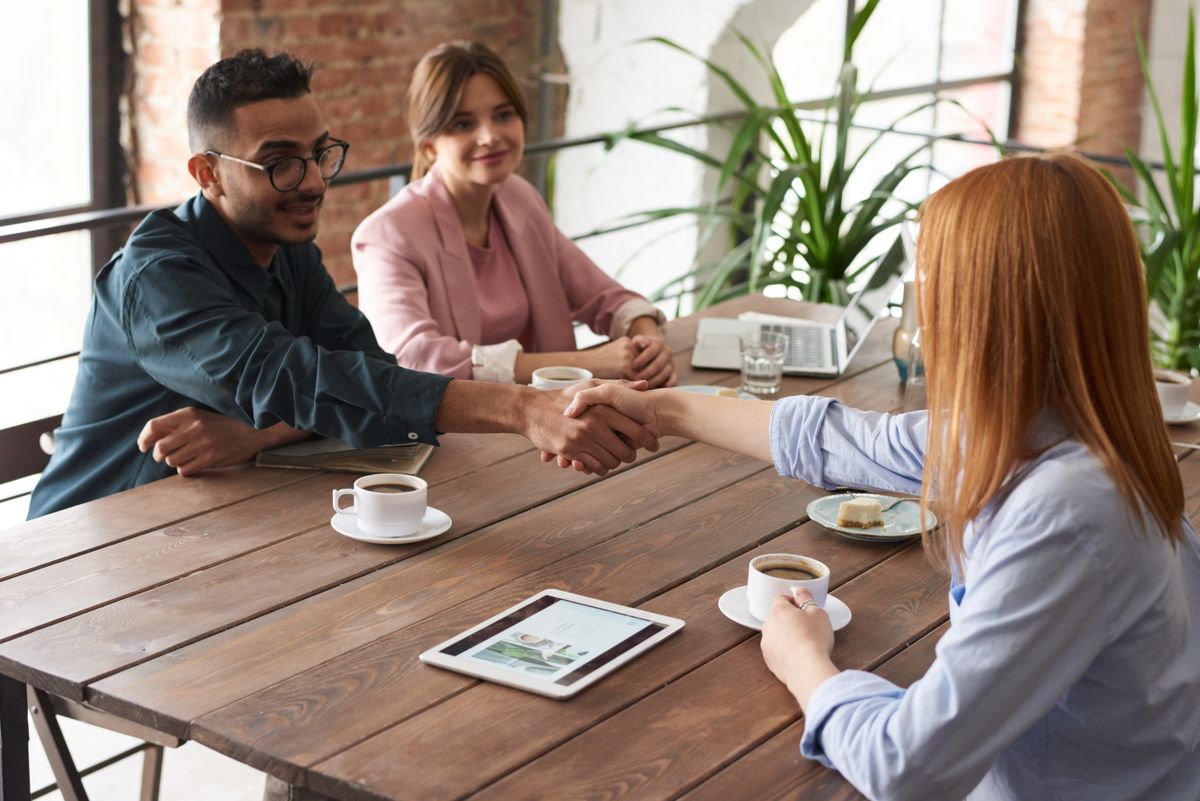 Colleagues shaking hands across a table after a discussion